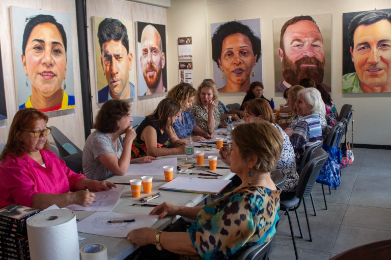 Adentrándose en el arte del retrato, grupo de adultos mayores forma parte de mediación cultural en la Sala de Exposiciones del Campus Providencia UDLA