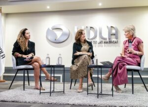 Tres mujeres exponiendo sentadas en auditorio