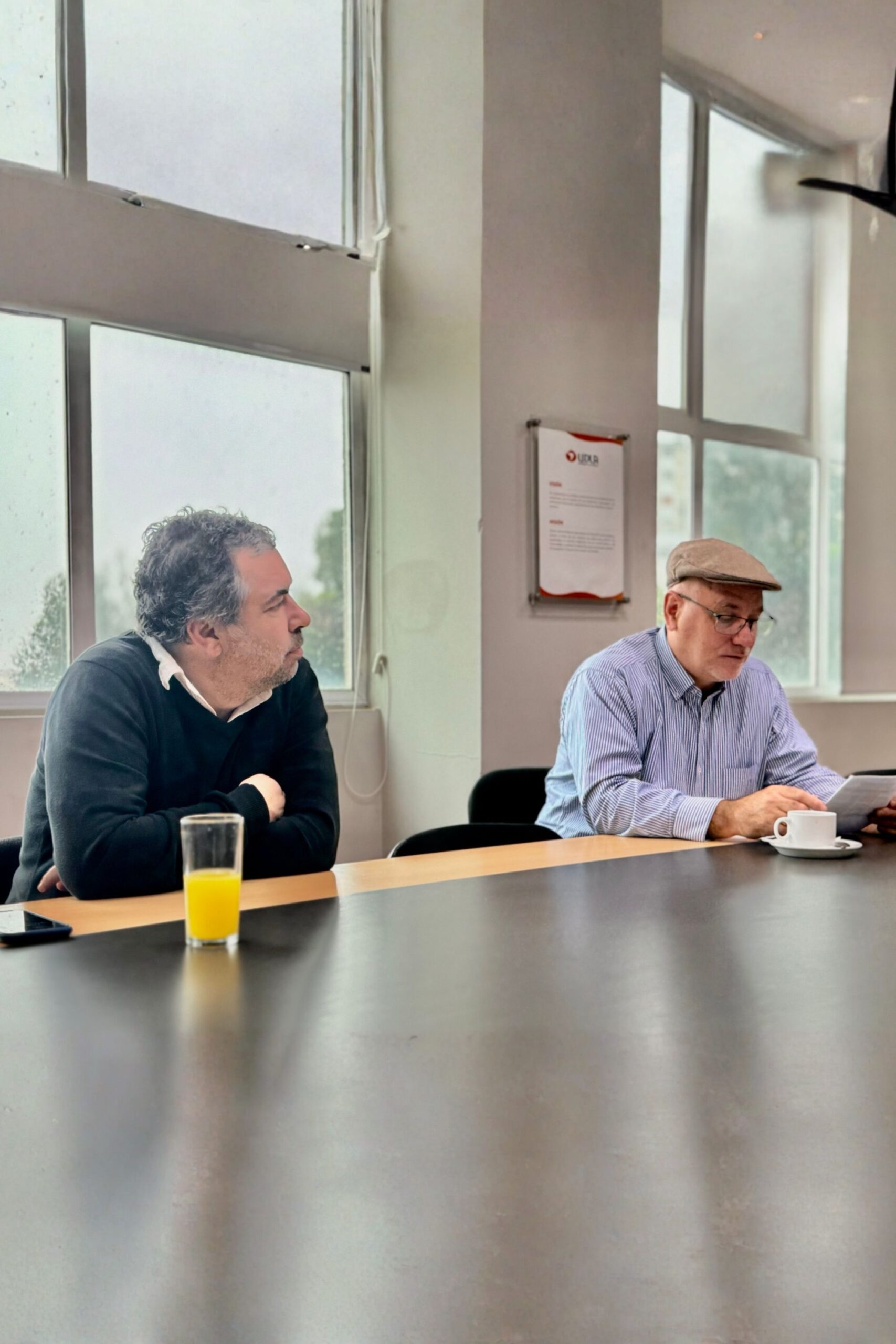 Dos hombres conversando en una mesa