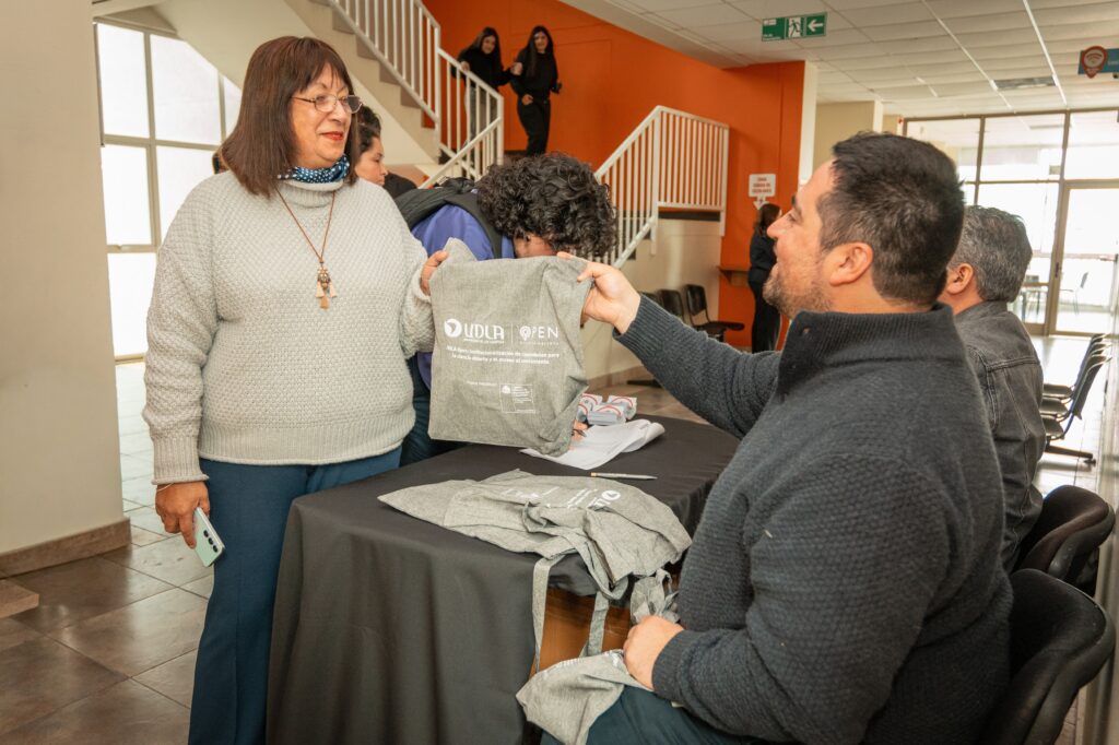 Mujer recibiendo bolsa de UDLAOpen